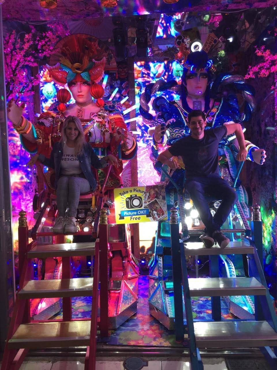 Hernán y su pareja subidos a dos carrozas de neón en un espectáculo de Shinjuku, en Tokio