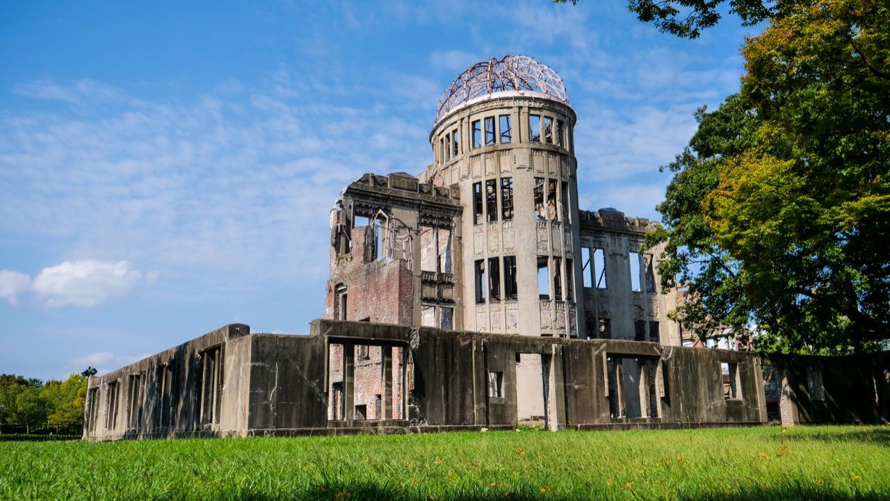 La cúpula Genbaku de Hiroshima, en ruinas y en pie, sobre el césped del parque de la Paz